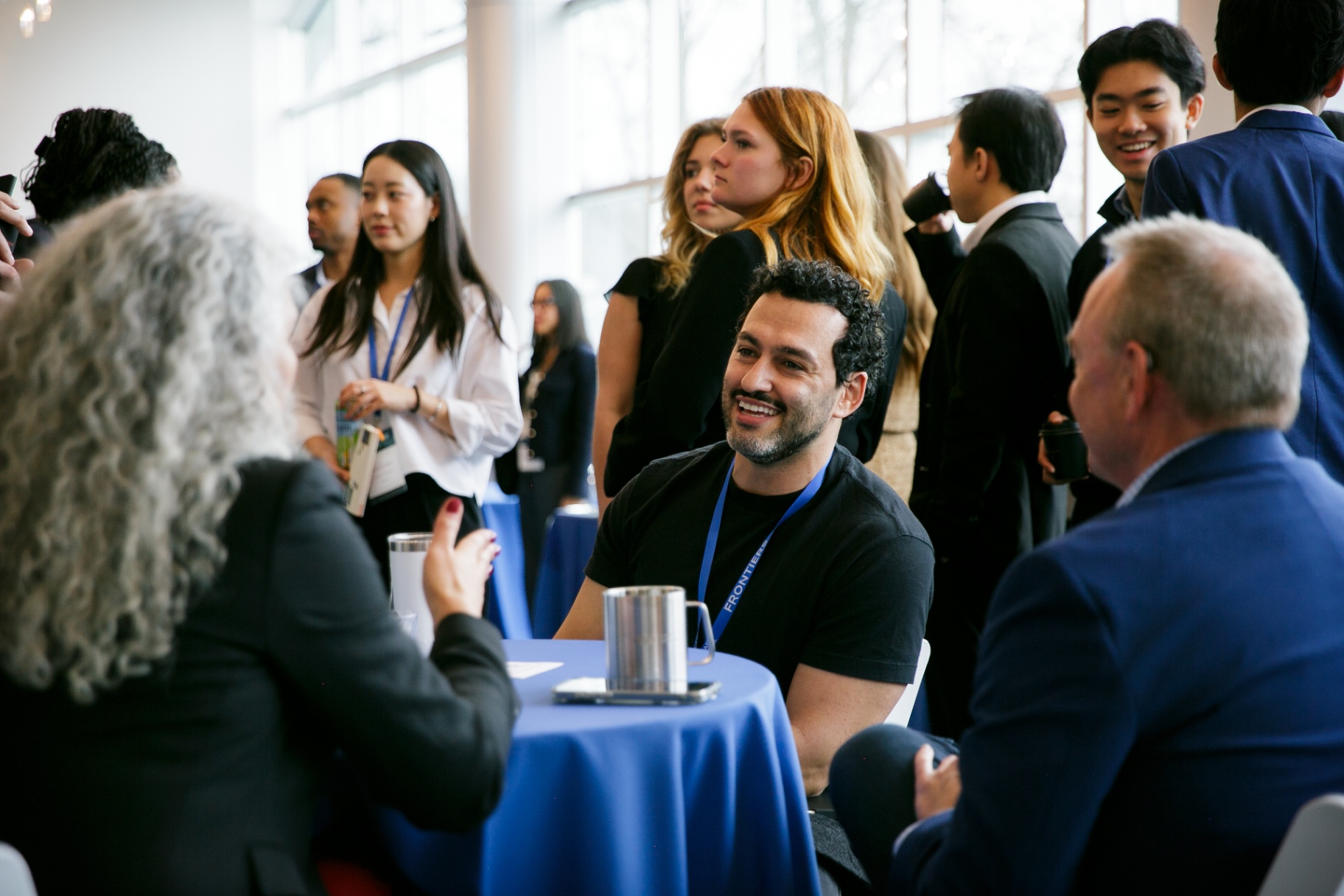 Attendees networking over coffee at a Frontiers cocktail table