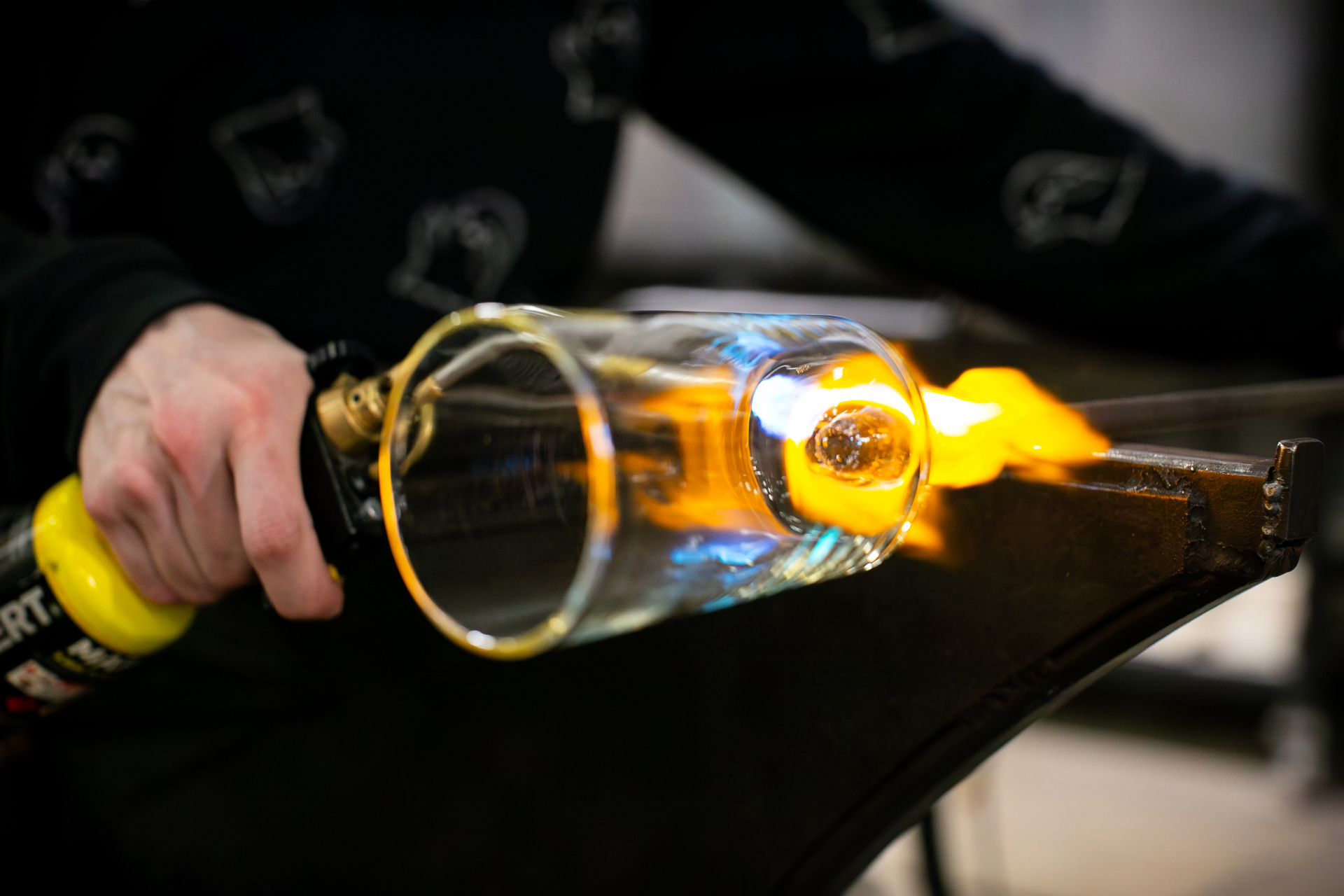Live glassblowing demonstration shaping molten glass at Frontiers 2026