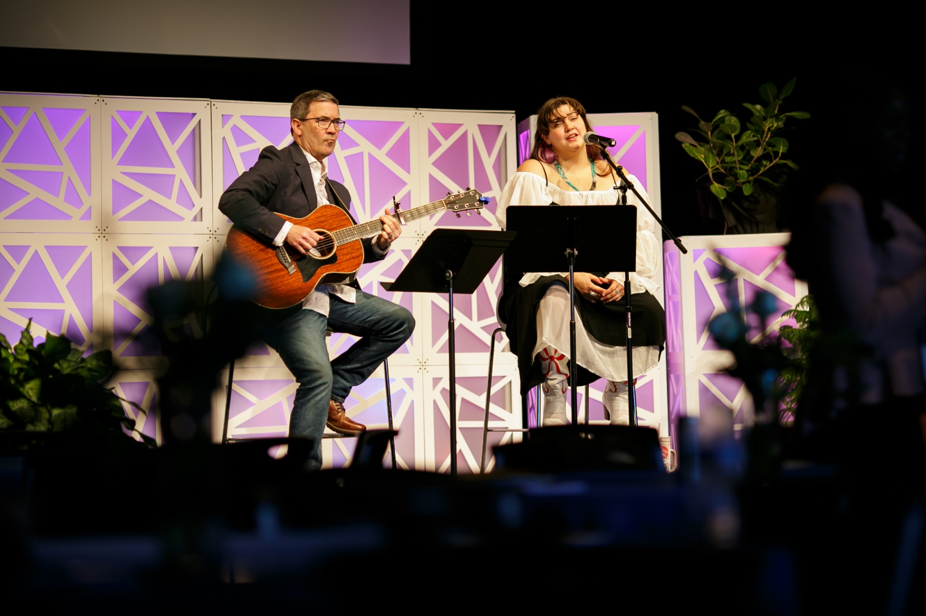 Duo performing acoustic music on stage at Frontiers 2026