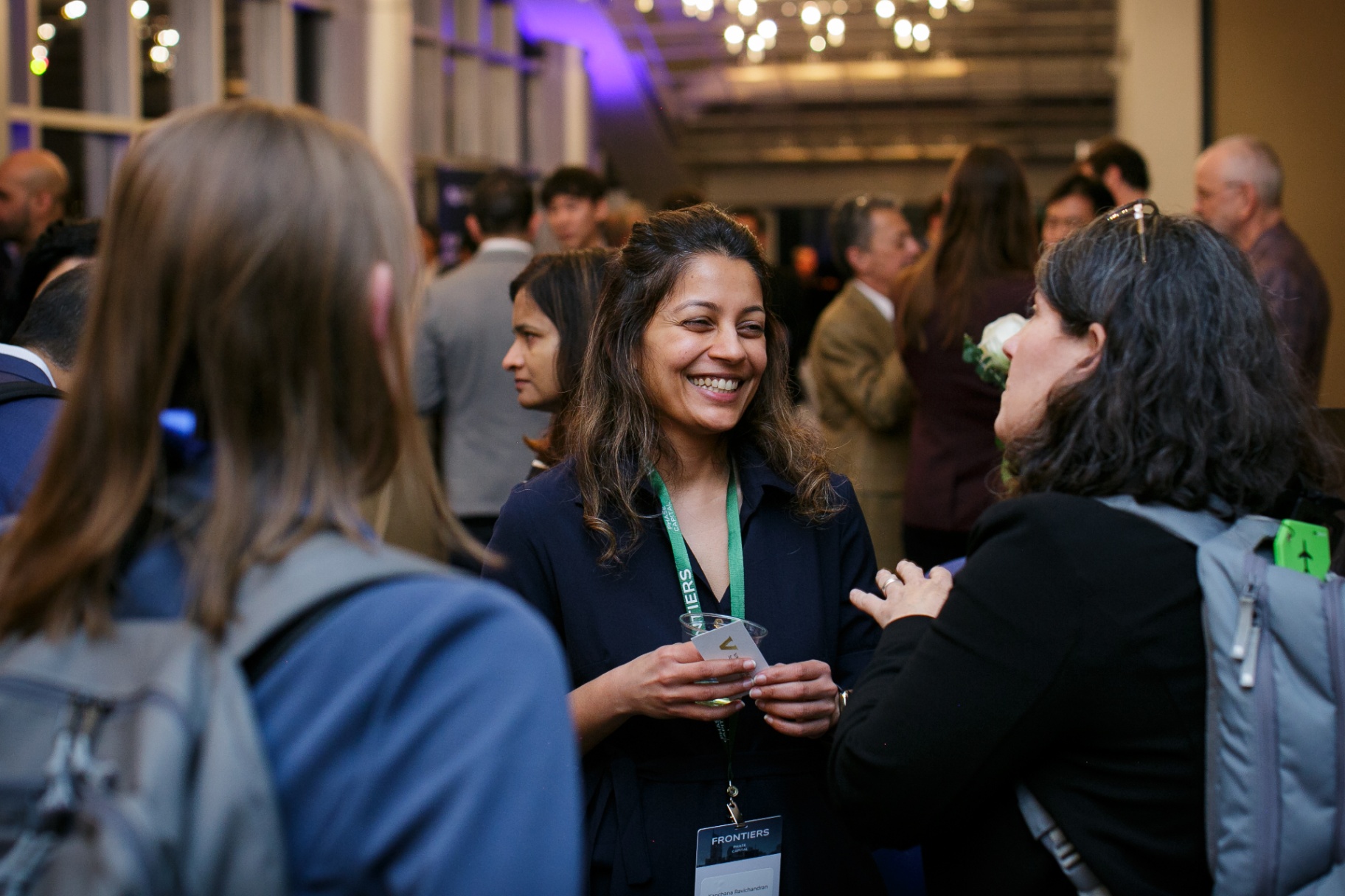 Attendees laughing and networking at the Frontiers evening reception