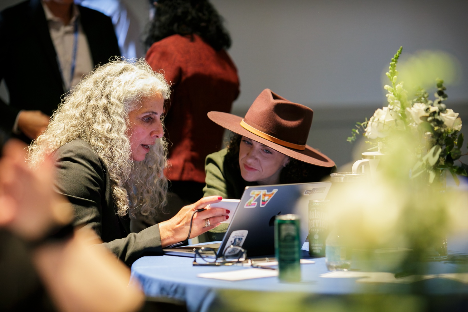 Two attendees collaborating over a laptop at a Frontiers table