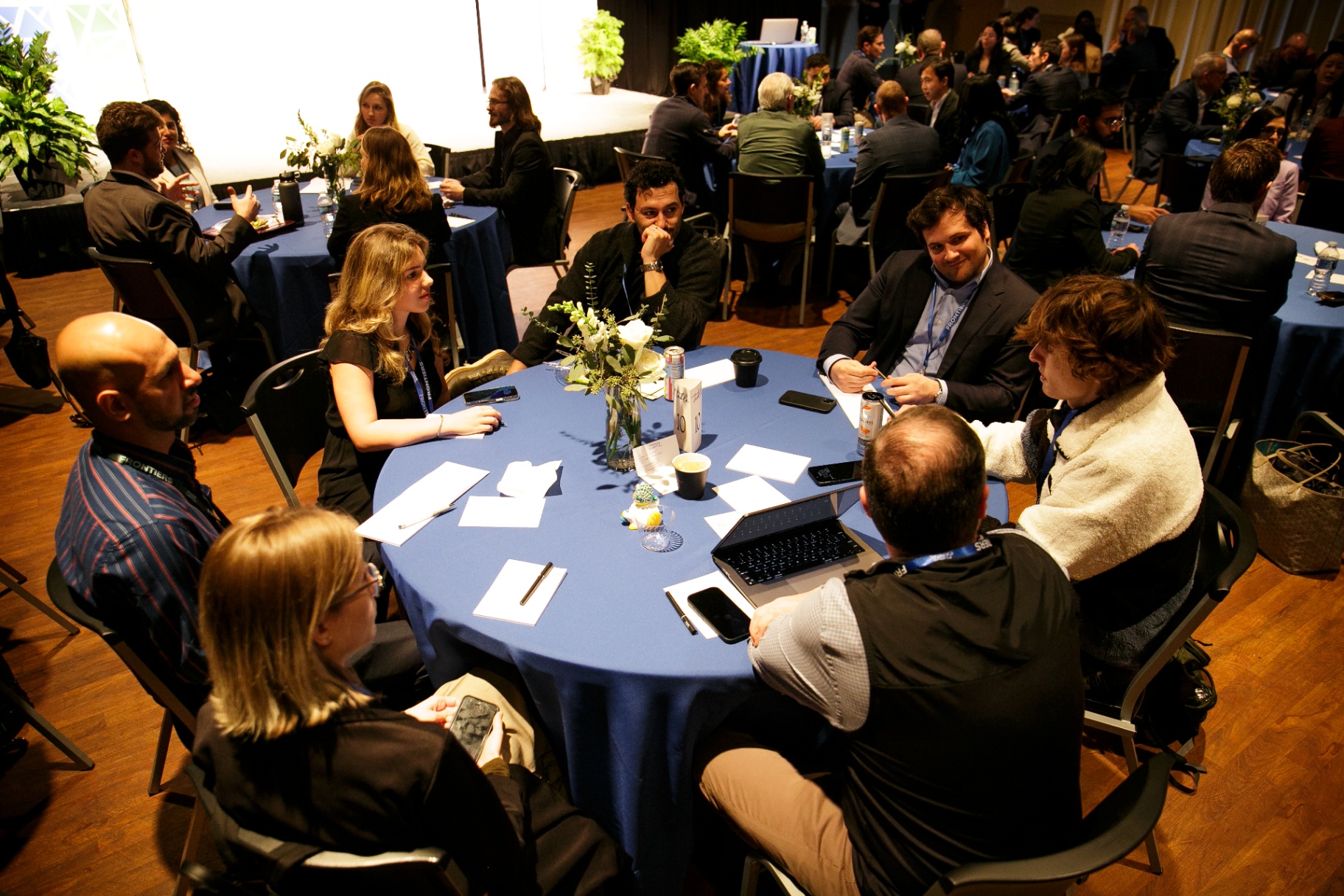 Attendees seated around a blue roundtable working through a session at Frontiers 2026